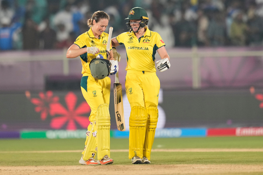 Australia's Ellyse Perry, left, and batting partner Kim Garth celebrate after their win in the ICC Women's Cricket World Cup match against India at ACA-VDCA Cricket Stadium in Visakhapatnam, India, Sunday, Oct. 12, 2025. (AP Photo/Aijaz Rahi)