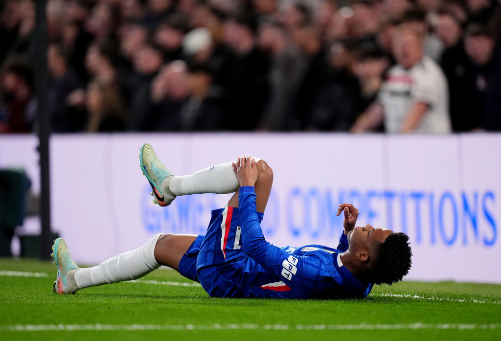 Chelsea's Estevao holds his leg after picking up an injury during the English Premier League soccer match in London, Saturday April 18, 2026. (John Walton/PA via AP)