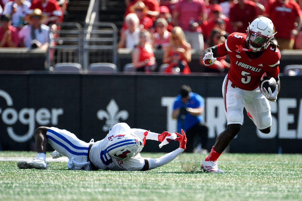 Louisville running back Keyjuan Brown (5) runs from a tackle-attempt by SMU cornerback Marcellus Barnes Jr. (8) during the first half of an NCAA college football game in Louisville, Ky., Saturday, Sept. 19, 2026. (AP Photo/Timothy D. Easley)