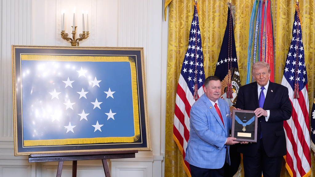 Chris Edmonds, left, son of Master Sergeant Roderick Edmonds, with President Donald Trump, is presented the Medal of Honor on behalf of his father, during a ceremony in the East Room of the White House, Monday, March 2, 2026, in Washington. (AP Photo/Alex Brandon)