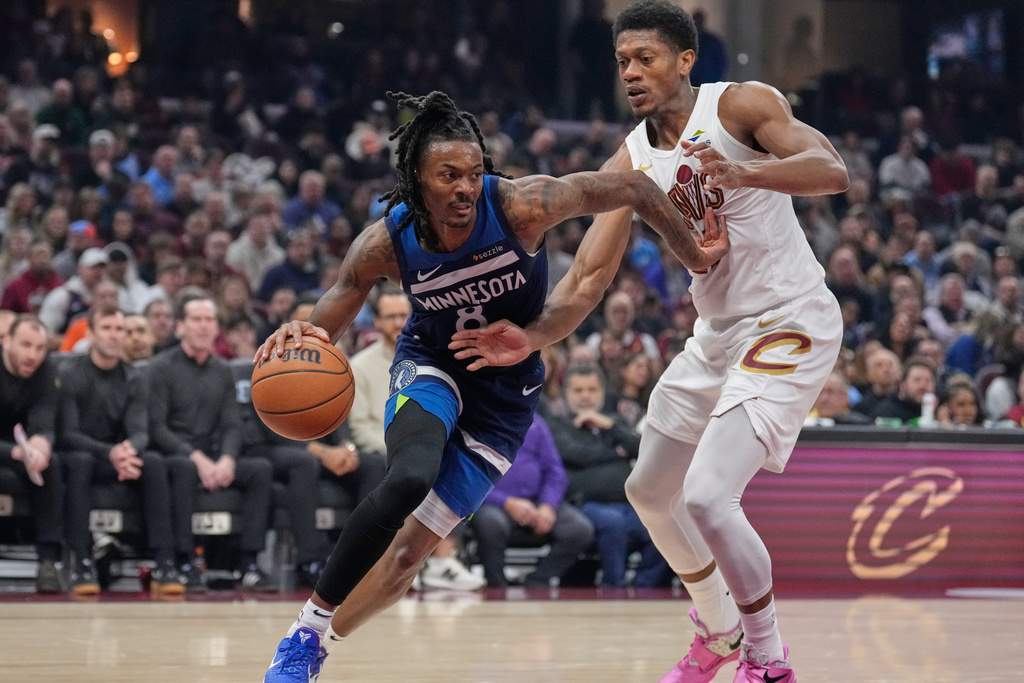 CORRECTS TO SATURDAY, JAN. 10, NOT SUNDAY, JAN. 4 - Minnesota Timberwolves guard Bones Hyland, left, drives past Cleveland Cavaliers forward De'andre Hunter, right, in the first half of an NBA basketball game Saturday, Jan. 10, 2026, in Cleveland. (AP Photo/Sue Ogrocki)