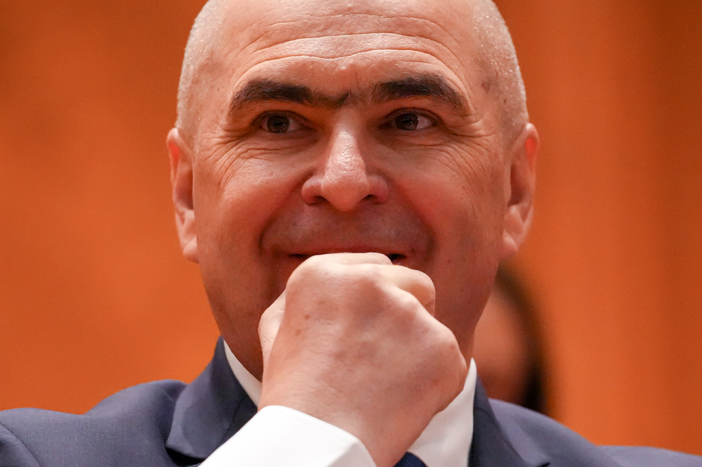 Romanian Prime Minister Ilie Bolojan grimaces during a parliament session ahead of a no confidence vote in Bucharest, Romania, Tuesday, May 5, 2026. (AP Photo/Vadim Ghirda)