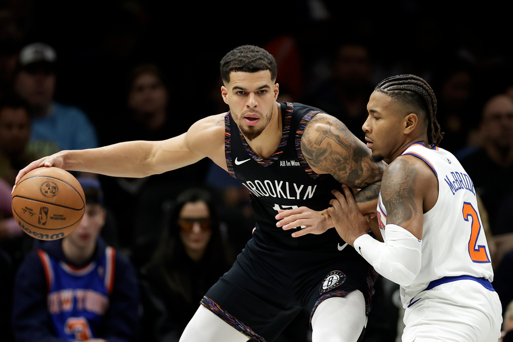 Brooklyn Nets forward Michael Porter Jr. looks to pass around New York Knicks guard Miles McBride (2) during the first half of an NBA basketball game, Monday, Nov. 24, 2025, in New York. (AP Photo/Adam Hunger)