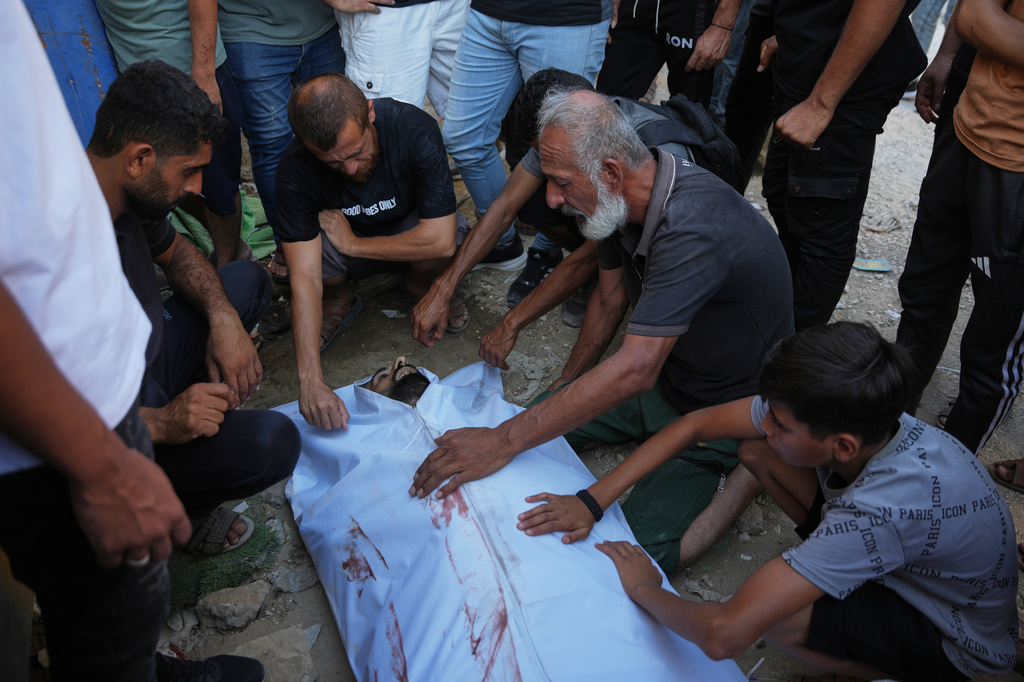 EDS NOTE: GRAPHIC CONTENT - Mourners take the last look at the body of a Palestinian man who was killed following an Israeli airstrike, during his funeral in Nuseirat, central Gaza Strip, Friday, July 17, 2026. (AP Photo/Abdel Kareem Hana)