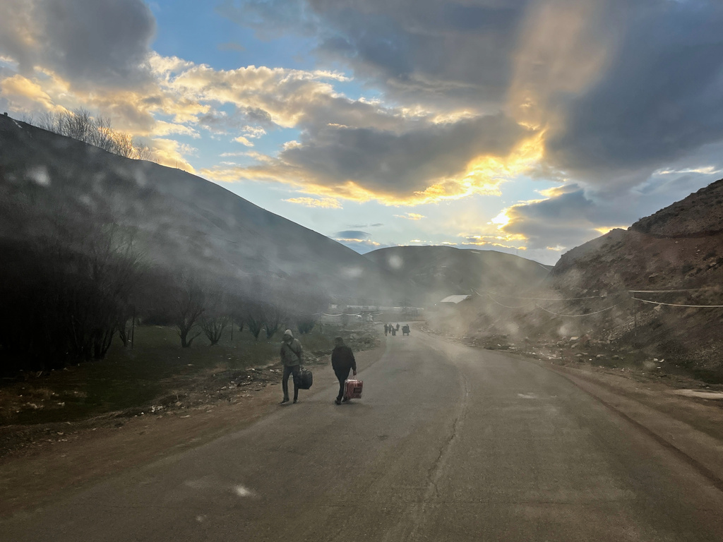 Travelers carry their bags as they walk from Turkey through border checkpoints into Iran at the Razi crossing near Razi, Iran, Thursday, April 9, 2026. (AP Photo/Francisco Seco)