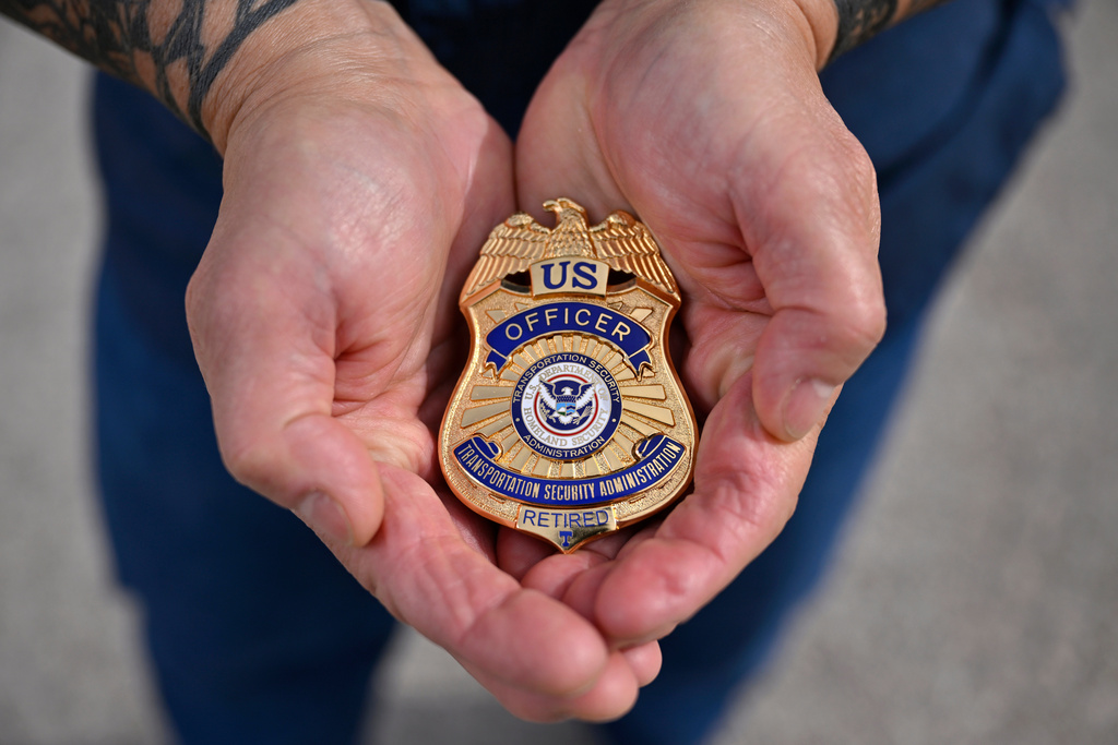 Kai Regan, a former Transportation Security Administration agent, displays his retired TSA badge on Tuesday, Nov. 11, 2025, in Las Vegas. (AP Photo/David Becker)