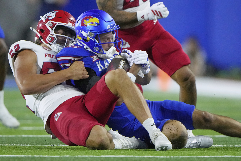 Fresno State long snapper Wesley Brown, left, tackles Kansas wide receiver Tate Nagy as he returns a punt during the second half of an NCAA college football game Saturday, Aug. 23, 2025, in Lawrence, Kan. (AP Photo/Charlie Riedel)