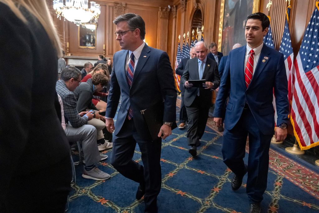 Speaker of the House Mike Johnson, R-La., left, leaves with Rep. Gabe Evans, R-Colo., right, after speaking with reporters at the Capitol in Washington, Thursday, Nov. 6, 2025. (AP Photo/Mark Schiefelbein)