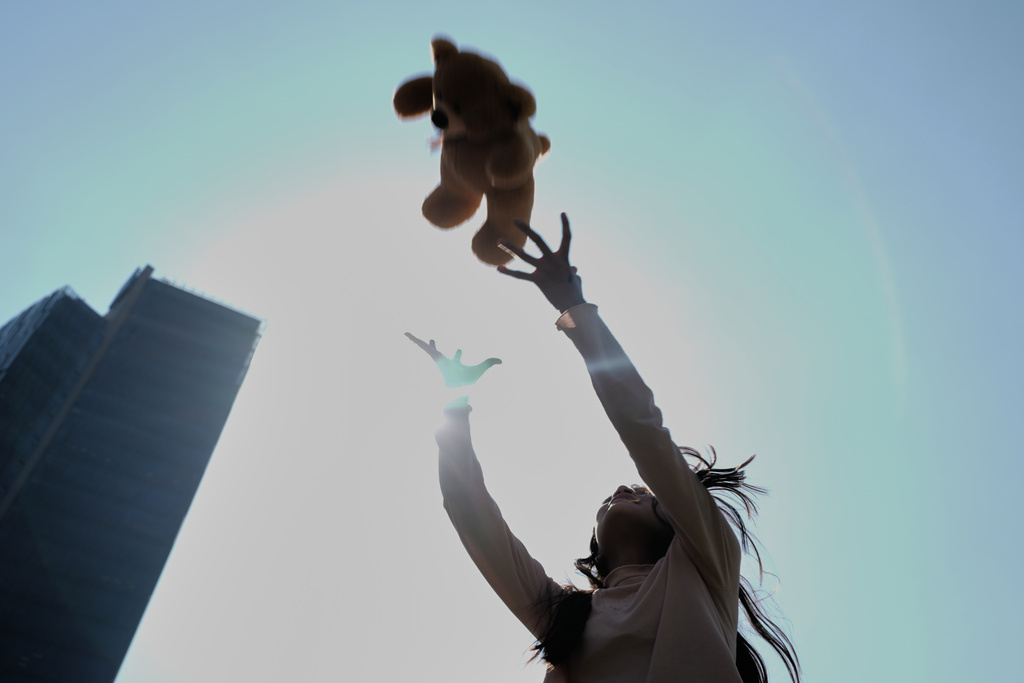 A child plays with the teddy bear she was gifted at an event celebrating Three Kings Day, at the Angel of Independence in Mexico City, Monday, Jan. 5, 2026. (AP Photo/Marco Ugarte)
