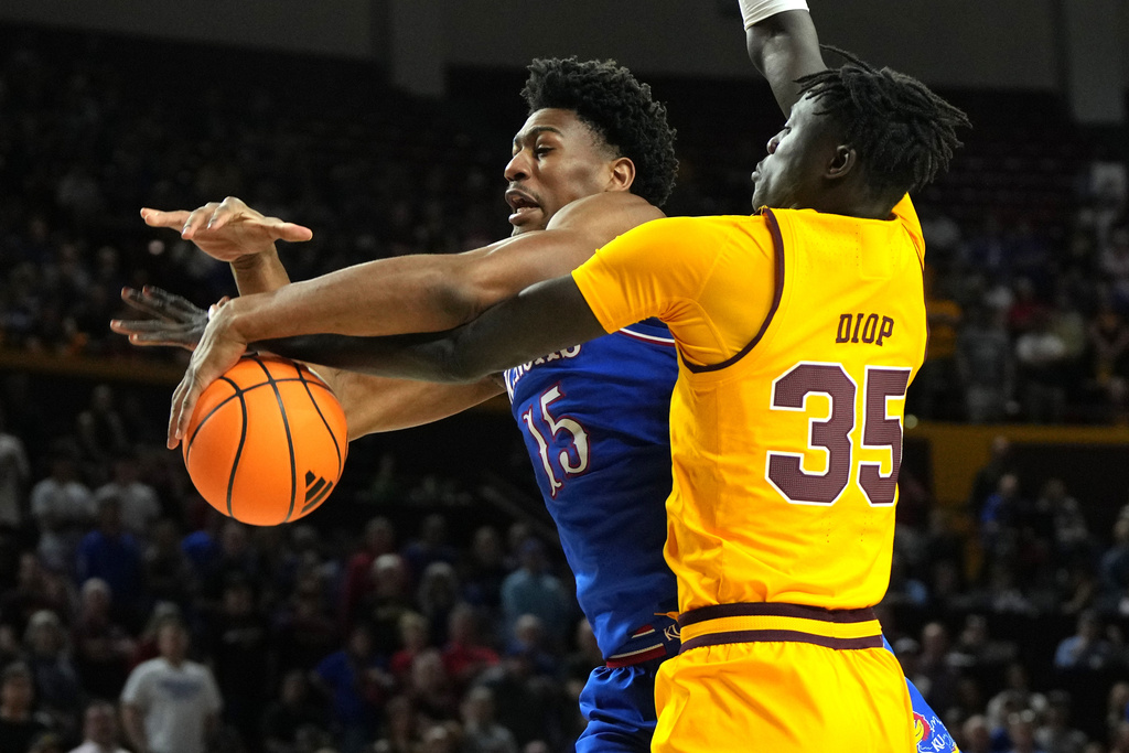 Arizona State center Massamba Diop fouls Kansas forward Bryson Tiller (15) during the first half of an NCAA college basketball game, Tuesday, March 3, 2026, in Tempe, Ariz. (AP Photo/Rick Scuteri)