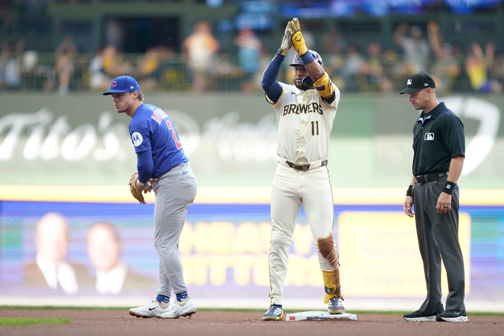 Milwaukee Brewers' Jackson Chourio (11) reacts to hitting a double as Chicago Cubs second baseman Nico Hoerner (2) looks on during the first inning in Game 1 of baseball's National League Division Series game Saturday, Oct. 4, 2025, in Milwaukee. (AP Photo/Kayla Wolf)