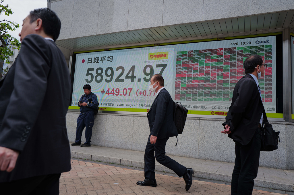 People walk in front of an electronic stock board showing Japan's Nikkei index at a securities firm Monday, April 20, 2026, in Tokyo. (AP Photo/Eugene Hoshiko)