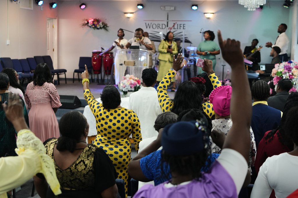Members of the Word of Life Center, a church and hub of the Haitian community, sing and pray during a service in Salisbury, Md., Sunday, Aug. 2, 2026. (AP Photo/Luis Andres Henao)