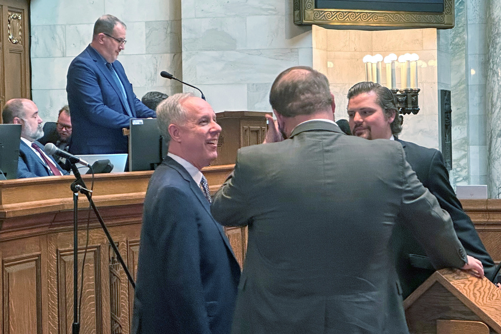 Republican Wisconsin Assembly Speaker Robin Vos, foreground left, speaks with Majority Leader Tyler August, center, and Rep. Nate Gustafson, right, on the floor of the Assembly on Tuesday, Jan. 13, 2026, in Madison, Wis. (AP Photo/Scott Bauer)