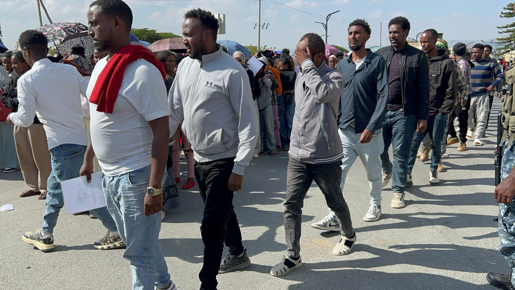 In this photo made with a smartphone, former Tigrayan fighters line up for a disarmament, demobilization and reintegration program in Mekelle, Ethiopia, Thursday, Oct. 15, 2026. The program, overseen by Ethiopia's National Rehabilitation Commission, is part of the 2022 Pretoria peace agreement, which renewed fighting has effectively shattered. (AP Photo/Filmon Equar Hailu)