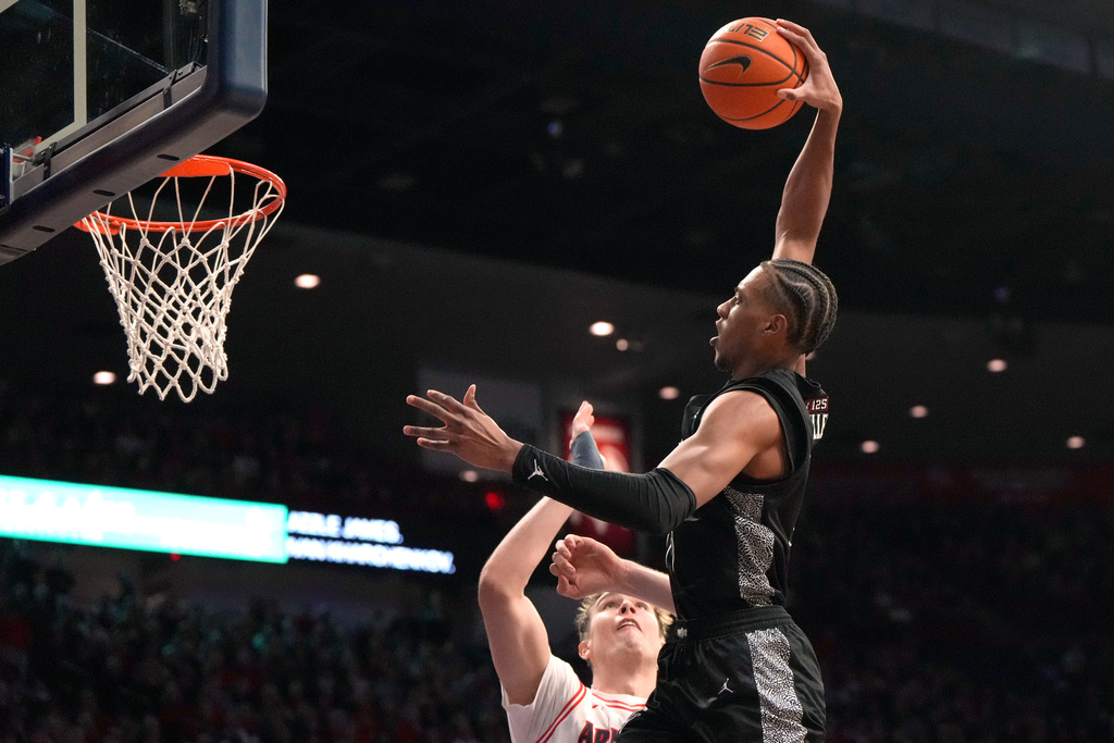 Cincinnati forward Baba Miller (18) dunks over Arizona center Motiejus Krivas during the first half of an NCAA college basketball game, Wednesday, Jan. 21, 2026, in Tucson, Ariz. (AP Photo/Rick Scuteri)