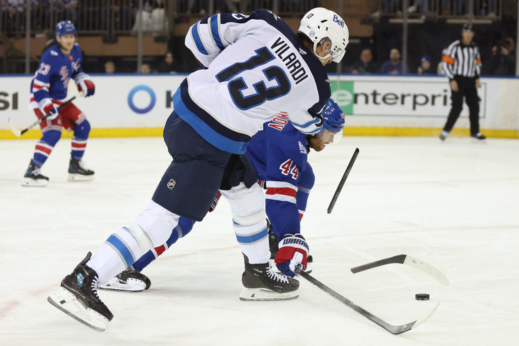 Winnipeg Jets center Gabriel Vilardi (13) has his stick broken after a blocked shot-attempt by New York Rangers defenseman Vladislav Gavrikov (44) during the second period of an NHL hockey game, Sunday, March 22, 2026, in New York. (AP Photo/Heather Khalifa)