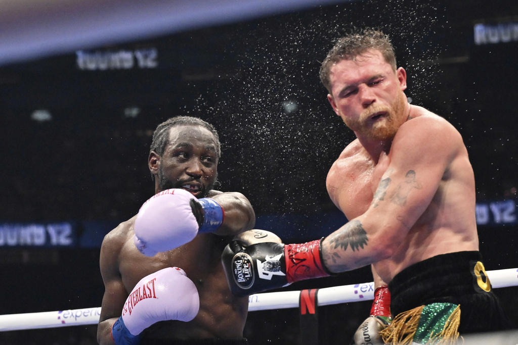 Terence Crawford propina un puñetazo al mexicano Saúl "Canelo" Álvarez en un combate por los títulos de los supermedianos, el sábado 13 de septiembre de 2025, en Las Vegas (AP Foto/David Becker)