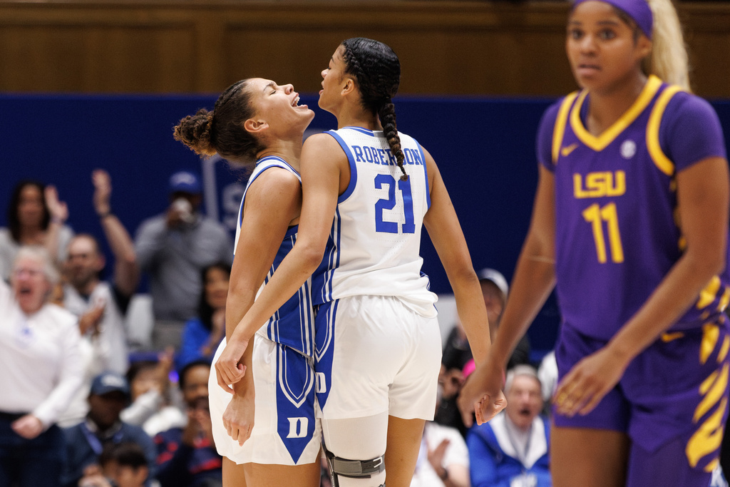 Duke's Arianna Roberson (21) and Duke's Delaney Thomas, left, celebrate behind LSU's Zakiyah Johnson (11) after a play during the first half of an NCAA college basketball game in Durham, N.C., Thursday, Dec. 4, 2025. (AP Photo/Ben McKeown)