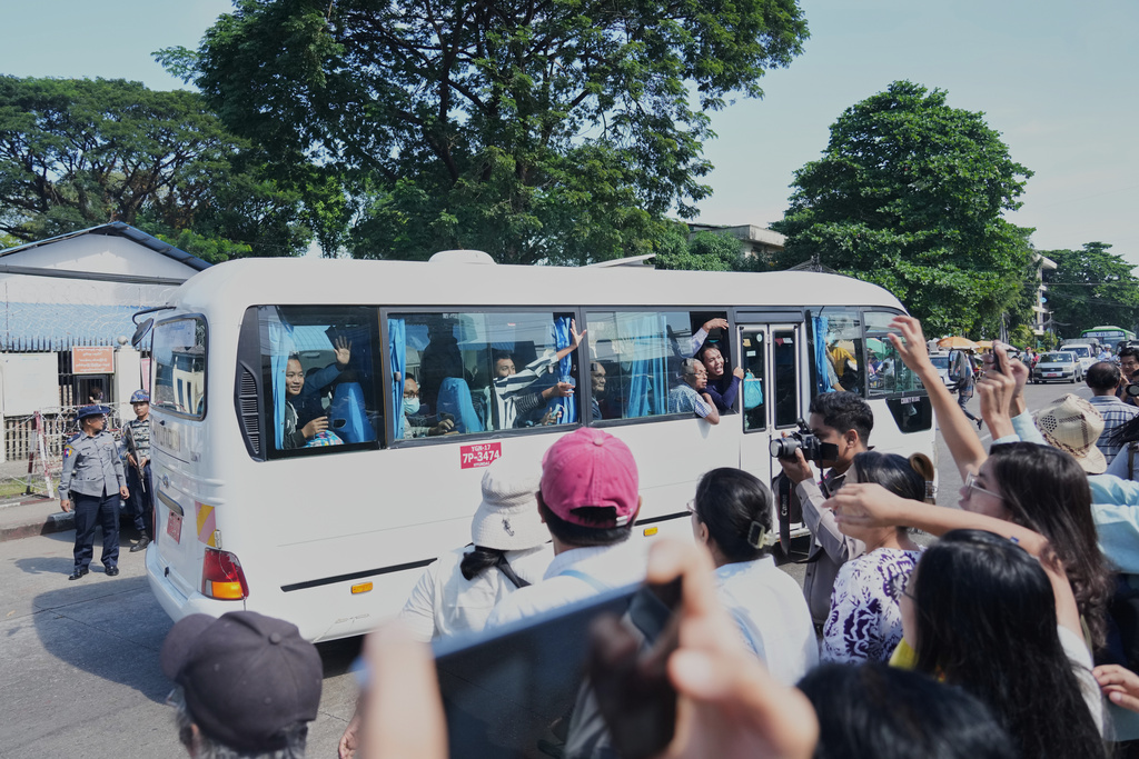Released prisoners on bus are welcomed by family members and colleagues outside the main gate of Insein prison, Thursday, Nov. 27, 2025, in Yangon, Myanmar, after Myanmar's military rulers granted a mass amnesty ahead of elections. (AP Photo/Thein Zaw)
