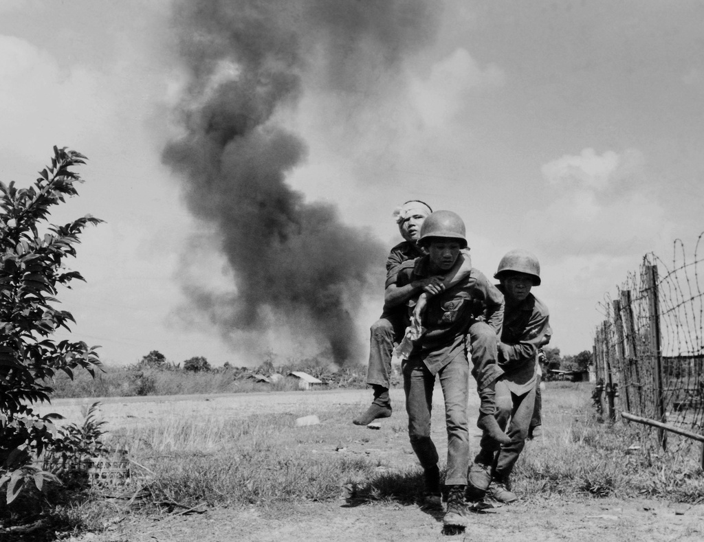 FILE - A wounded soldier is carried during fighting on Highway 13, north of Saigon, Oct. 14, 1972, where government troops are trying to reopen road to the Lai Khe base. (AP Photo/Dang Van Phuoc, File)