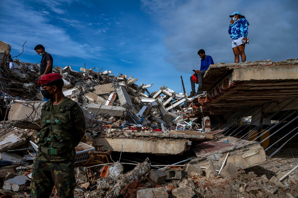 Volunteers and rescuers help to find survivors in a collapsed building in Caraballeda, La Guaira state, Venezuela, on June 30, 2026, following the June 24 twin earthquakes. (Miguel Medina/Pool Photo via AP)