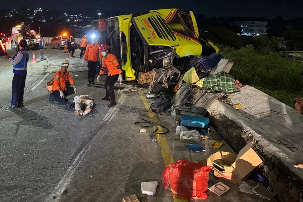 In this photo released by the Semarang Search and Rescue Office, rescuers tend to a victim of a deadly bus crash on a toll road in Semarang, Central Java, Indonesia, Monday, Dec. 22, 2025. (Semarang SAR Office via AP)