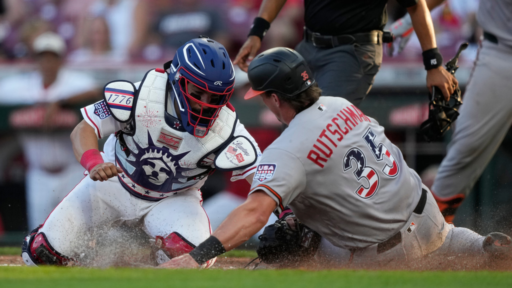 Baltimore Orioles Adley Rutschman, right, is tagged out by Cincinnati Reds catcher Jose Trevino, left, during the third inning of a baseball game in Cincinnati, Saturday, July 4, 2026. (AP Photo/Carolyn Kaster)