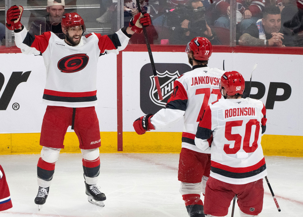 Carolina Hurricanes defenseman Shayne Gostisbehere (4) celebrates after his goal with teammates Mark Jankowski (77) and Eric Robinson (50) during the first period of Game 3 of the Eastern Conference finals NHL hockey Stanley Cup playoff series against the Montreal Canadiens in Montreal, Monday, May 25, 2026. (Christinne Muschi/The Canadian Press via AP)