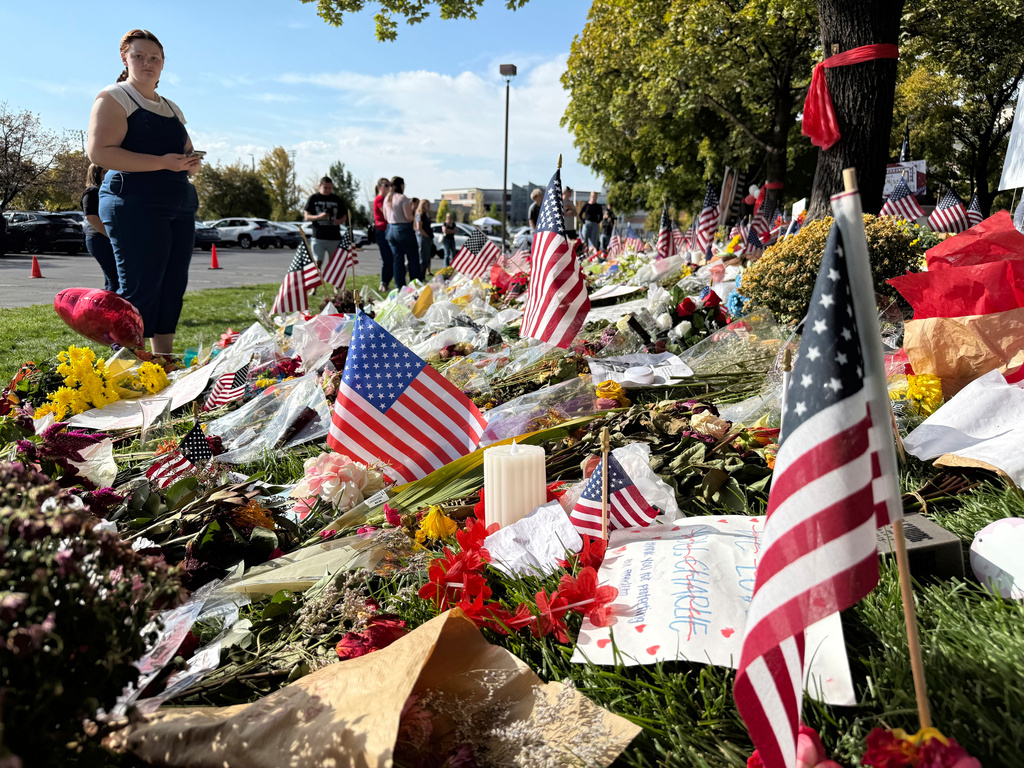 American flags and flowers are displayed at a memorial for Charlie Kirk at Utah Valley University, Monday, Sept. 15, 2025, in Orem, Utah. (AP Photo/Jesse Bedayn)