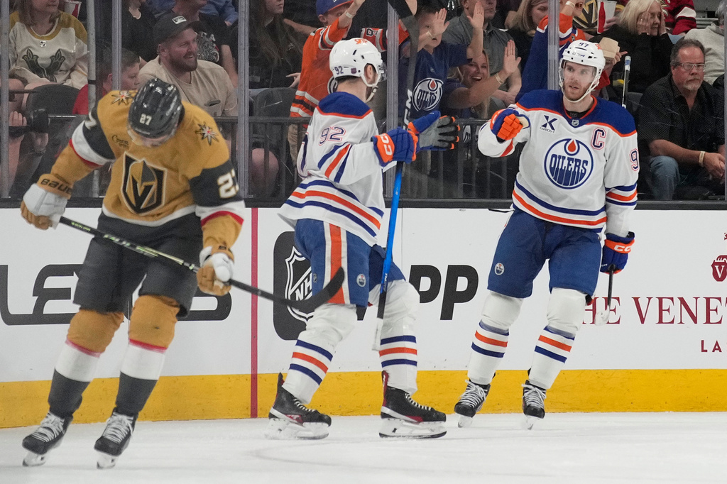 FILE - Edmonton Oilers center Connor McDavid, right, celebrates after scoring against the Vegas Golden Knights during the second period of an NHL hockey game, March 26, 2026, in Las Vegas. (AP Photo/John Locher, File)