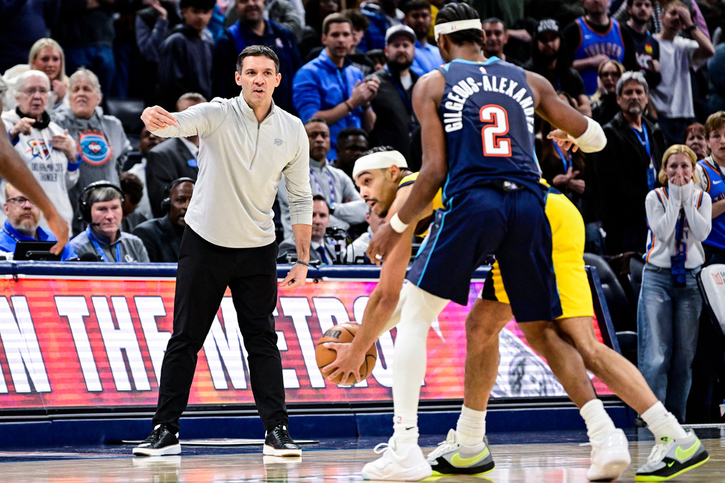 Oklahoma City Thunder head coach Mark Daigneault, front left, gestures to Thunder guard Shai Gilgeous-Alexander (2) during the second half of an NBA basketball game against the Indiana Pacers, Friday, Jan. 23, 2026, in Oklahoma City. (AP Photo/Gerald Leong)