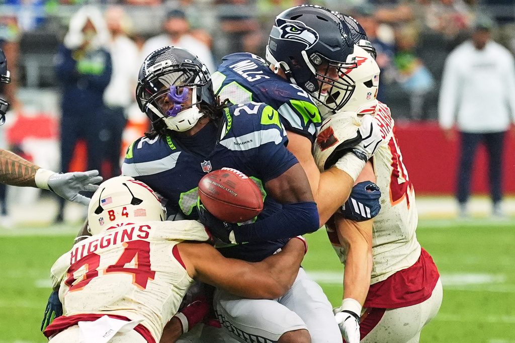 Arizona Cardinals tight end Elijah Higgins (84) causes Seattle Seahawks wide receiver Rashid Shaheed (22) to fumble the ball on a kick return, which is recovered by the Seahawks during the second half of an NFL football game in Glendale, Ariz., Sunday, Sept. 20, 2026. (AP Photo/Ross D. Franklin)