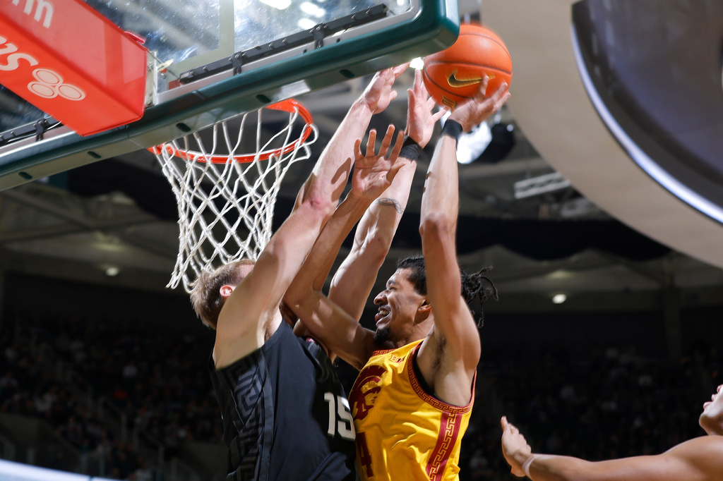 Michigan State center Carson Cooper (15) blocks a shot by Southern California forward Chad Baker-Mazara, second from left, during the first half of an NCAA college basketball game, Monday, Jan. 5, 2026, in East Lansing, Mich. (AP Photo/Al Goldis)