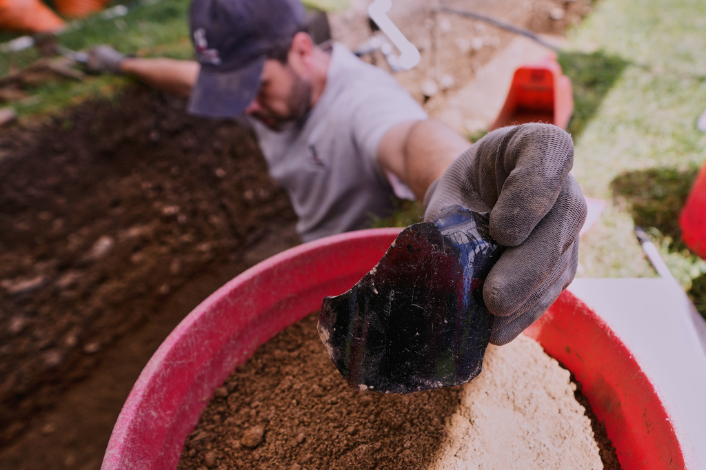 Joe Bagley, the City of Boston Archeologist, holds a portion of a bottle that was unearthed during an archaeological dig at the site of the Battle of Bunker Hill, Monday, June 15, 2026, in Boston. (AP Photo/Charles Krupa)