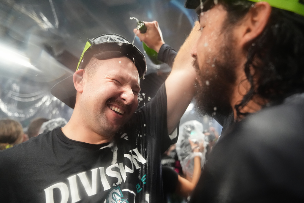 Seattle Mariners catcher Cal Raleigh, left, and starting pitcher Andres Munoz celebrate after the team's win against the Colorado Rockies to clinch the American League West Division, Wednesday, Sept. 24, 2025, in Seattle. (AP Photo/Ryan Sun)