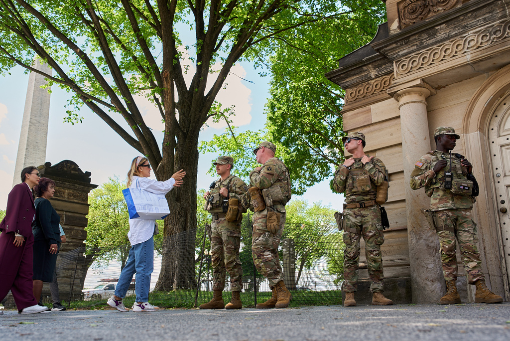 A tourist asks members of the Florida National Guard for directions on the National Mall, across from the Washington Monument, Friday April 17, 2026, in Washington. (AP Photo/Jacquelyn Martin)