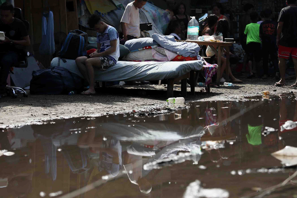Residents gather their belongings as they evacuate from their damaged homes in General Santos, southern Philippines, Thursday, June 11, 2026, following Monday's powerful earthquake. (AP Photo/Basilio Sepe)