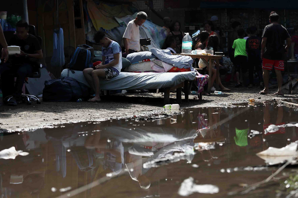 Residents gather their belongings as they evacuate from their damaged homes in General Santos, southern Philippines, Thursday, June 11, 2026, following Monday's powerful earthquake. (AP Photo/Basilio Sepe)