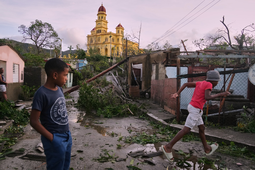 Boys walk in El Cobre, Cuba, in the aftermath of Hurricane Melissa on Wednesday, Oct. 29, 2025. (AP Photo/Ramon Espinosa)