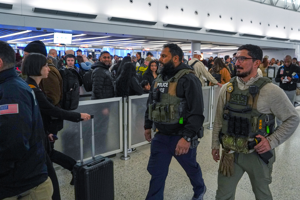 Federal immigration agents walk through Terminal 5 at John F. Kennedy International Airport (JFK) in the Queens borough of New York, Monday, March 23, 2026. (AP Photo/Ryan Murphy)