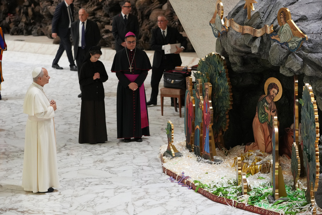 Pope Leo XIV prays in front of Nacimiento Gaudium, a nativity scene set in the Paul VI Hall adorned with 28,000 ribbons representing lives saved from abortion according to Catholic organizations, during an audience with donors of the Christmas tree and of the nativity scenes, at the Vatican Monday, Dec. 15, 2025. (AP Photo/Alessandra Tarantino)