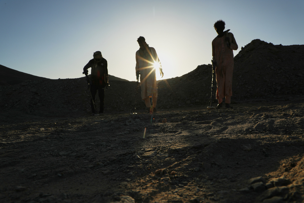 Miners use metal detectors to search for gold at an artisanal mining site in Dalago Mahas, Sudan's Northern State, Thursday, May 7, 2026. (AP Photo/Mohnd Blal)