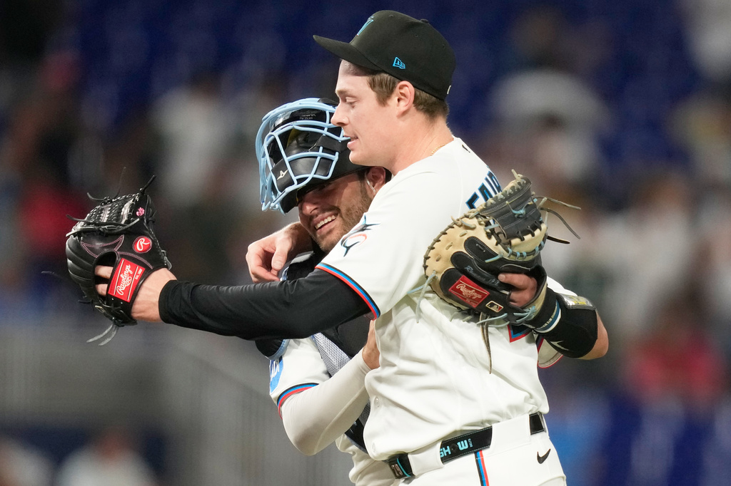 Miami Marlins catcher Joe Mack, left, and relief pitcher Pete Fairbanks, right, embrace after the Marlins defeated the Seattle Mariners in a baseball game, Wednesday, July 8, 2026, in Miami. (AP Photo/Lynne Sladky)