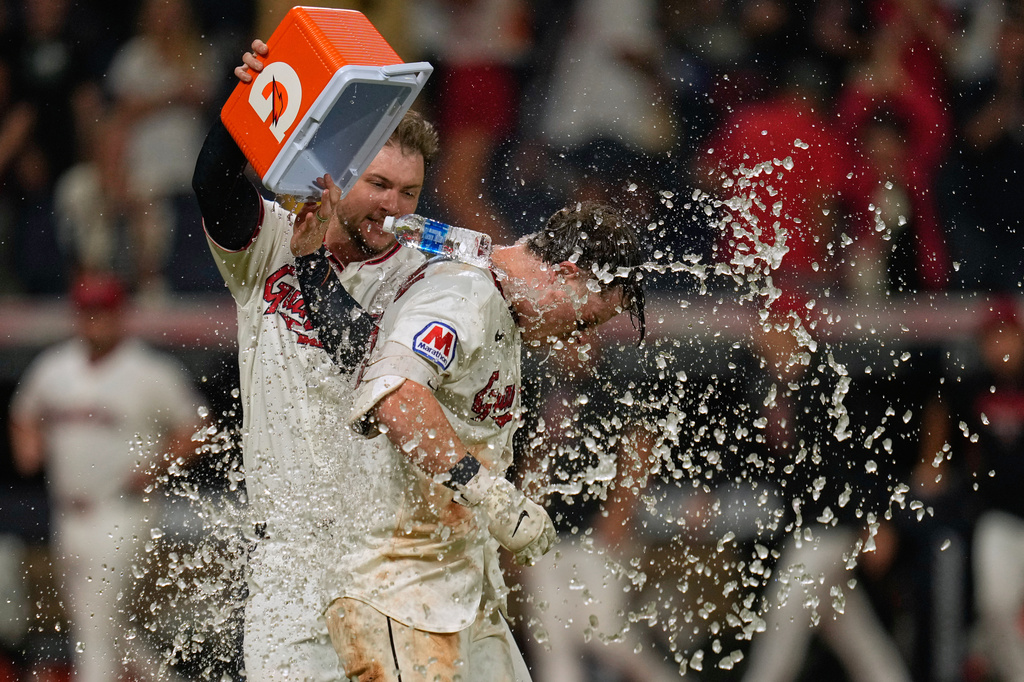 Cleveland Guardians catcher Patrick Bailey, left, douses Travis Bazzana, right, with a cooler after Bazzana hit a game winning home run in the ninth inning of the second baseball game of a split doubleheader against the Pittsburgh Pirates in Cleveland, Saturday, June 18, 2026. (AP Photo/Sue Ogrocki)