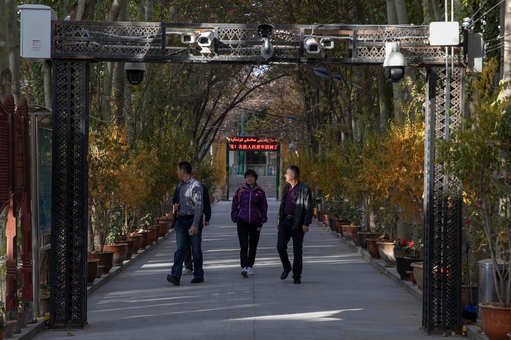 Visitos walk under security cameras at a mosque in Kashgar, in western China's Xinjiang region, on Sunday, Nov. 5, 2017. (AP Photo/Ng Han Guan)