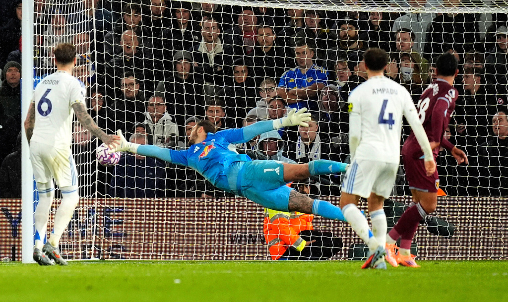 Leeds United's goalkeeper Lucas Perri dives in vain as West Ham United's Mateus Fernandes, right, scores their side's first goal during the English Premier League soccer match between Leeds United and West Ham United at Elland Road, Leeds, England, Friday Oct. 24, 2025. (Danny Lawson/PA via AP)
