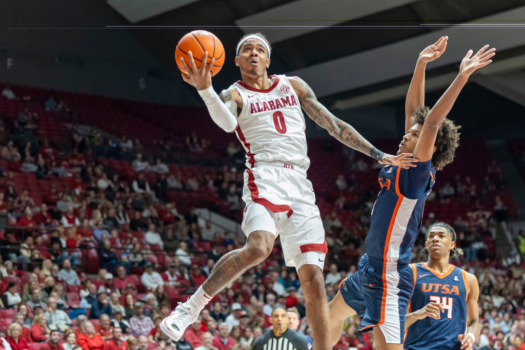 Alabama guard Labaron Philon Jr., left, looks to shoot past UTSA guard Dorian Hayes, front right, during the first half of an NCAA college basketball game, Sunday, Dec. 7, 2025, in Tuscaloosa, Ala. (AP Photo/Vasha Hunt)