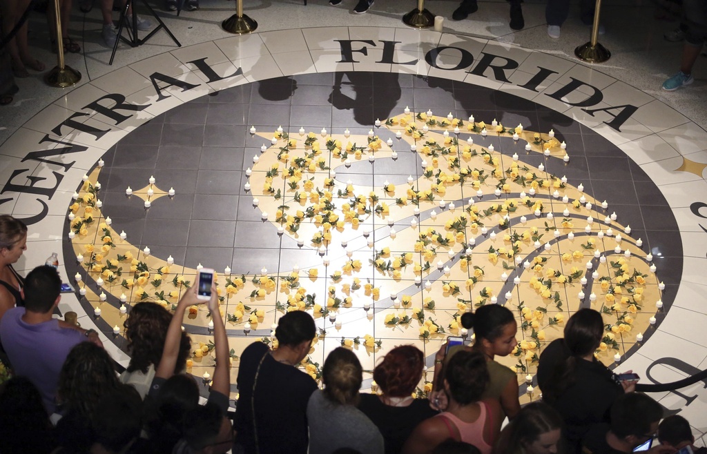 FILE - Students gather around lit candles surrounding the UCF logo, June 14, 2016. (Stephen M. Dowell/Orlando Sentinel via AP, file)