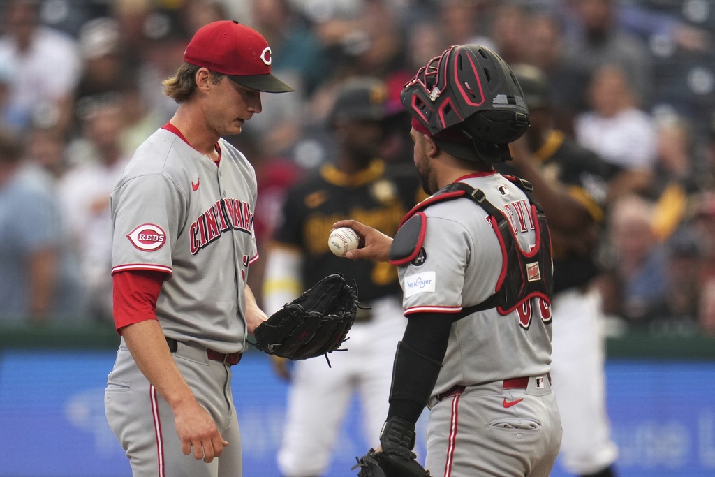 Cincinnati Reds pitcher Brady Singer, left, gets the ball back from catcher Jose Trevino during the first inning of a baseball game against the Pittsburgh Pirates in Pittsburgh, Thursday, Aug. 7, 2025. (AP Photo/Gene J. Puskar)